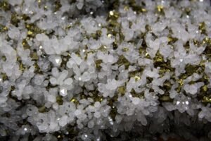 Detailed view of white crystals with golden pyrite showcasing natural mineral patterns and textures.